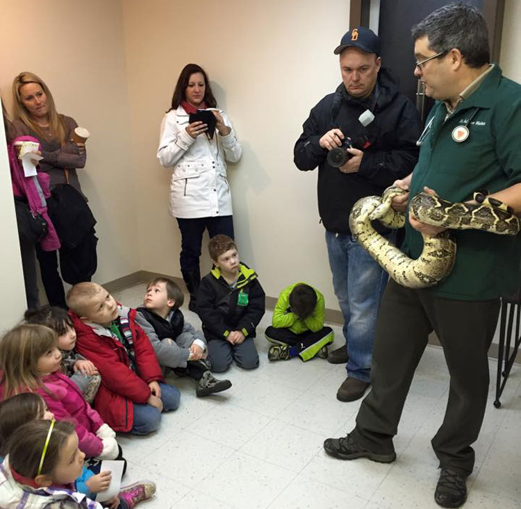 Dr. Walton showing a snake to kindergarten students